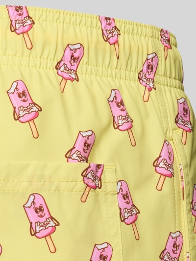 Produktfoto, Badehose im Allover-Look Modell 'MAUI VIBES NOVELTY' von Jack & Jones, krój regular fit, elastyczny pas, żółty materiał z różowym wzorem lodów, gładka tekstura