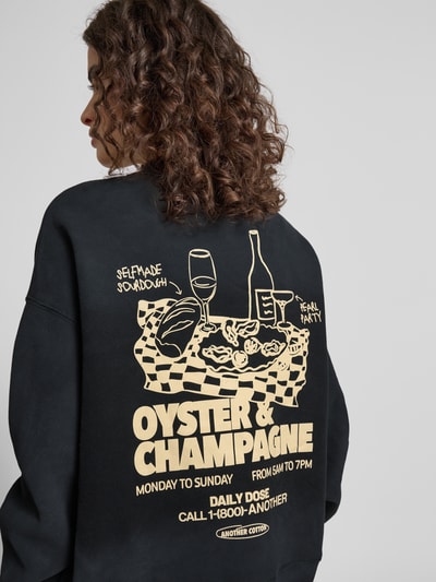 Kobieta modelka nosi Regular Fit Sweatshirt mit Logo-Print od ANOTHER COTTON LAB, mieszanka bawełny, stójka, nadruk z logo, elastyczne wykończenia, widok od tyłu na całą sylwetkę.