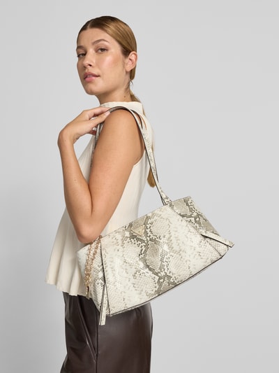 Frauenmodel trägt Shoulder Bag mit Allover-Schlangen-Print Modell 'Devon' von GUESS in Beige und Grau, Reißverschluss, Logo-Detail, Ganzkörperansicht von vorne.