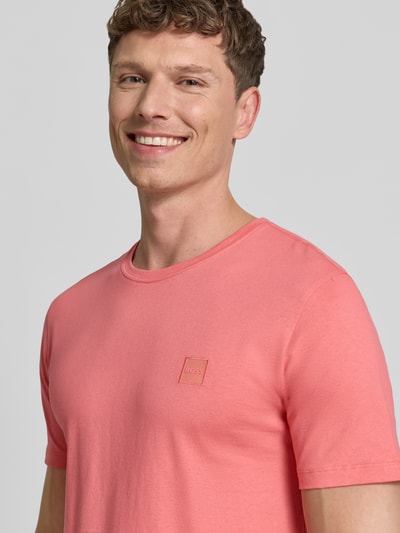 Männermodel trägt Regular Fit T-Shirt aus reiner Baumwolle Modell 'TALES' von BOSS Orange in Unifarbe, Nahaufnahme Oberkörper.