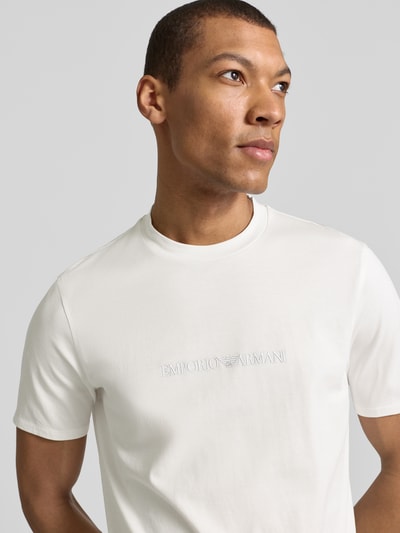 Männermodel trägt Regular Fit T-Shirt mit Logo-Detail von Emporio Armani aus reiner Baumwolle, Rundhalsausschnitt, Nahaufnahme Oberkörper.