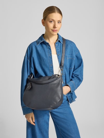 Frauenmodel trägt Handtasche aus Leder Modell 'JUNA' von Abro, dunkelblau, strukturierte Oberfläche, Hauptfach mit Reißverschluss, Tragehenkel, Schulterriemen, Ganzkörperansicht von vorne.