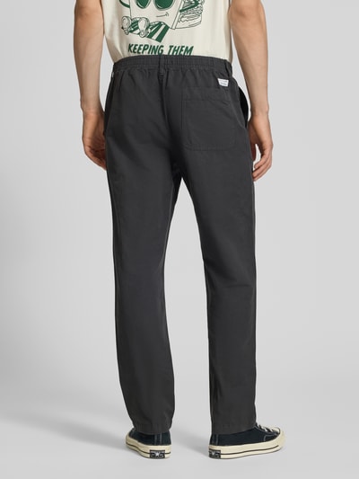 Männermodel trägt Relaxed Fit Chino aus Baumwolle-Leinen-Mix Modell 'FILIP RELAXED' von Marc O'Polo Denim, Optik: Unifarben, Passform: Relaxed-Fit, Applikation: Label-Patch, Details: Gürtelschlaufen, Verschluss: Knopf und Reißverschluss, Bundabschluss: elastisch, Material: Baumwolle-Leinen-Mix, dunkel, glatte Textur, Ganzkörperansicht Rückansicht.