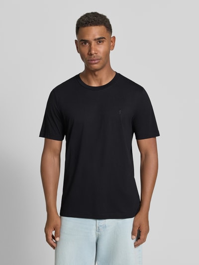Männermodel trägt Regular Fit T-Shirt aus reiner Baumwolle Modell 'JAAMES' von ARMEDANGELS in Schwarz, glatte Textur, Ganzkörperansicht von vorne. Herren T-Shirt von ARMEDANGELS.