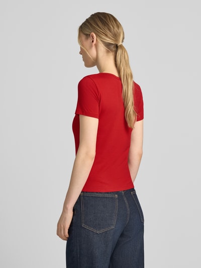 Vrouwenmodel draagt Slim Fit T-shirt met doorlopende knoopsluiting van Jake*s, mix van katoen en modal, rode kleur, ruglengte maat S 49 cm, ganzlichaamsaanzicht achteraan.