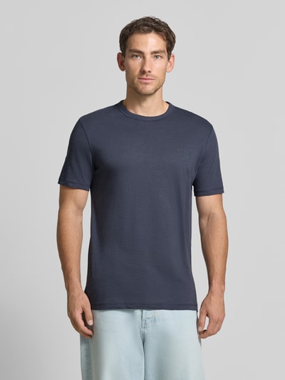 Męski model nosi Regular Fit T-Shirt aus Baumwoll-Mix Modell 'Tegood' von BOSS Orange, ciemnoniebieski odcień, gładka tekstura, Ganzkörperansicht von vorne.