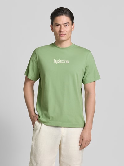 Männermodel trägt Regular Fit T-Shirt aus reiner Baumwolle Modell 'HASPEN' von SELECTED HOMME, Optik: Unifarben, Schriftzug, Rundhals, Kurzarm, Ganzkörperansicht von vorne.