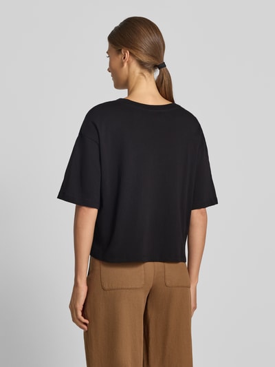 Vrouwenmodel draagt t-shirt met paillettenbesatz van Armani Exchange, puur katoen, los model, ronde hals, ruglengte maat S 45 cm, geheelfiguur achteraanzicht