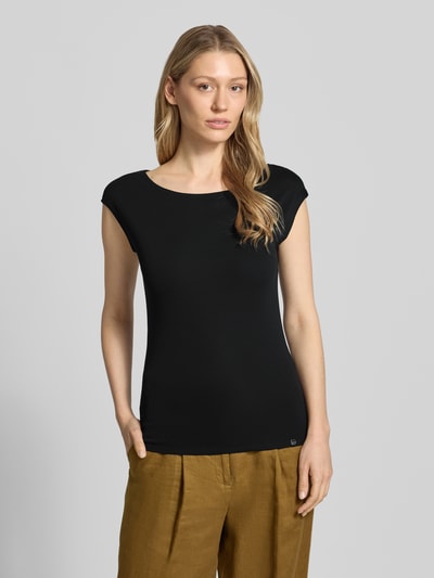 Frauenmodel trägt T-Shirt mit U-Boot-Ausschnitt und Label-Detail von Marc Cain, Baumwoll-Mix, körpernaher Schnitt, Nahaufnahme Oberkörper.