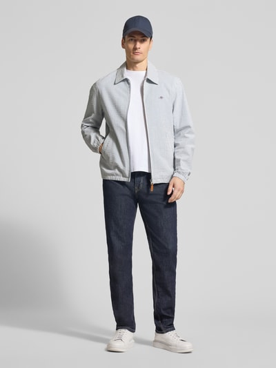 Männermodel trägt Jacke mit Zweiwege-Reißverschluss und Label-Stitching von Gant aus Baumwoll-Elasthan-Mix, Regular-Fit, Ganzkörperansicht von vorne.