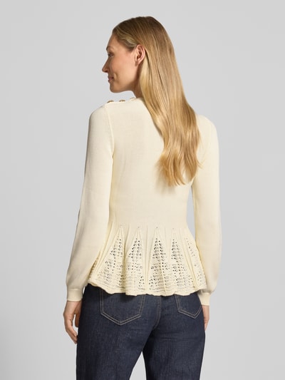 Frauenmodel trägt Strickshirt mit Schößchen Modell 'UTAMA' von Bash, mieszanka bawełny i modalu, dopasowany krój, okrągły dekolt, ozdobne guziki, baskinka z perforowaniem, prążkowane zakończenia rękawów, długość tyłu w rozmiarze S: 58 cm, długość rękawów w rozmiarze S: 63 cm, jasny kolor, tekstura dzianiny i ażurowa baskinka, Ganzkörperansicht Rückansicht.