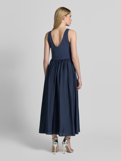Modelka nosi Abendkleid mit Rückenausschnitt und breiten Trägern von Christian Berg Cocktail, granatowy, materiał z domieszką stretchu, fason A-linia, długość midi, szerokie ramiączka, głęboki dekolt na plecach, szerokość w rozmiarze 36: 40 cm, długość tyłu: 132 cm, widok całej sylwetki od tyłu.