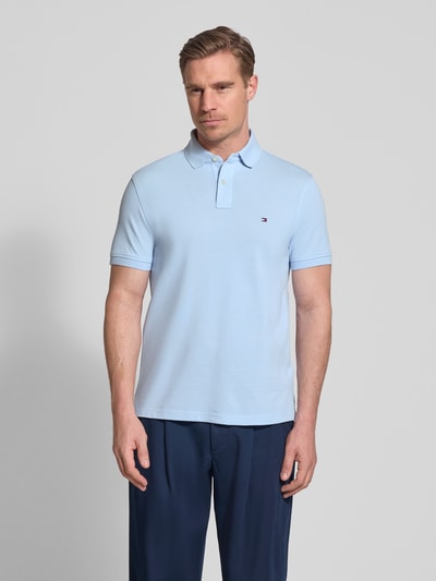 Männermodel trägt Regular Fit Poloshirt aus Baumwoll-Mix von Tommy Hilfiger, Optik: Unifarben, Logo-Stitching, Ganzkörperansicht von vorne.