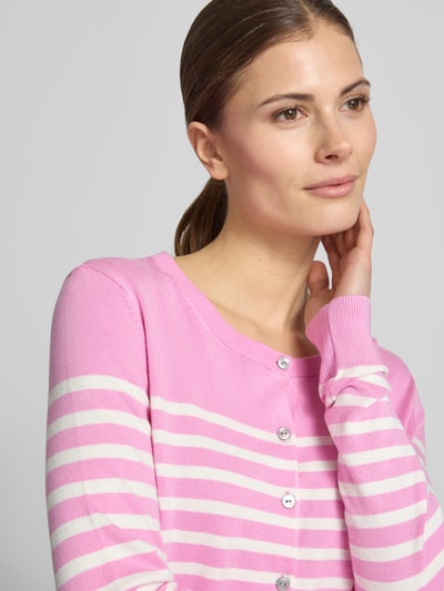 Frauenmodel trägt Strickjacke aus Viskose-Mix mit Streifenmuster von Christian Berg Woman in Pink und Weiß mit Knopfleiste, Nahaufnahme Oberkörper.