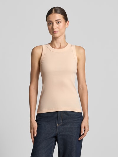 Kobiece modelka nosi Skinny Fit Tanktop aus reiner Baumwolle von DRYKORN w kolorze jasnobeżowym, efekt prążkowania, okrągły dekolt, długość tyłu 54 cm w rozmiarze S, widok całej sylwetki z przodu.