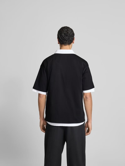 Männermodel trägt T-Shirt mit Label-Detail von Diesel in Schwarz mit weißen Akzenten aus reiner Baumwolle, Regular-Fit, Rückenlänge 69 cm, Ganzkörperansicht Rückansicht.