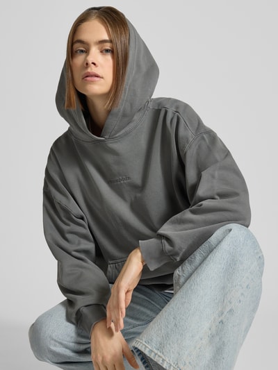 Vrouwenmodel draagt oversized Pegador Oversized Hoodie met logo en kangoeroezak van katoenmix model 'CLARITA', Nahaufnahme Oberkörper.