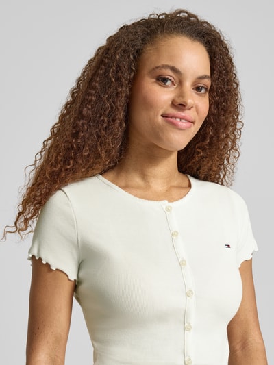 Frauenmodel trägt Slim Fit T-Shirt aus Baumwoll-Mix von Tommy Jeans, Optik: Unifarben, Logo-Stitching, Ripp, U-Boot-Ausschnitt, Kurzarm, Frill, Nahaufnahme Oberkörper.