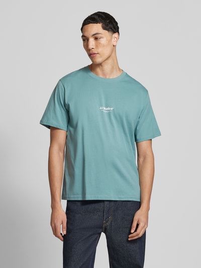 Männermodel trägt T-Shirt mit Logo und Rundhalsausschnitt von Jack & Jones in Türkis, reine Bio-Baumwolle, Regular Fit, Nahaufnahme Oberkörper.