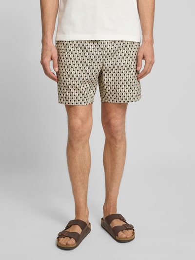 Männermodel trägt Relaxed Fit Bermudas aus Baumwoll-Viskose-Mix von Lacoste mit Allover-Muster, seitlichen Taschen, Ganzkörperansicht von vorne.