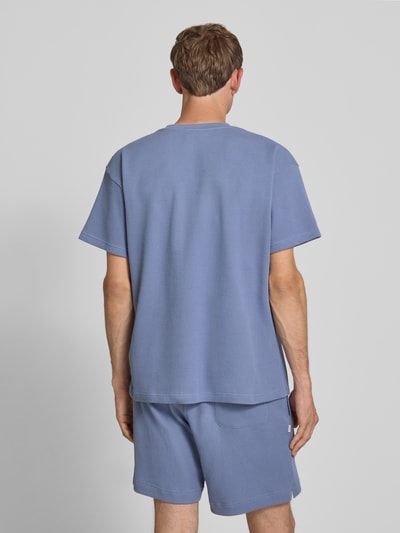 Mężczyzna nosi Henley-Shirt mit Strukturmuster und Label-Stitching von BLKVIS z bawełny, krój regular fit, okrągły dekolt, listwa guzikowa, długość tyłu w rozmiarze M: 72 cm, kolor jasnoniebieski, widok całej sylwetki od tyłu.