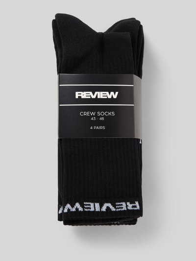 Produktfoto, Socken aus Baumwoll-Mix im 4er-Pack von REVIEW in Schwarz mit weißem Logo-Detail und elastischem Bund, strukturierte Oberfläche