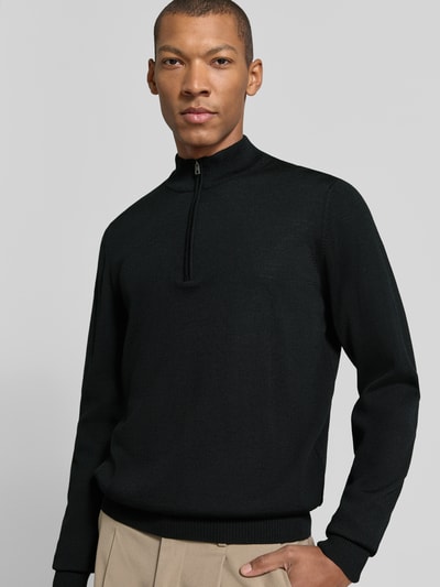 Mannenmodel draagt Regular Fit Sweatshirt aus reiner Schurwolle van MAERZ Muenchen in zwart met schipperskraag, elastische boordjes, Ruglengte maat 50: 69 cm, Mouwlengte maat 50: 68 cm. Nahaufnahme Oberkörper.