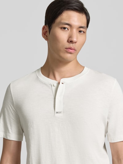 Männermodel trägt Regular Fit T-Shirt aus reiner Baumwolle von s.Oliver RED LABEL, Optik: Unifarben, Henley-Kragen, Kurzarm, Nahaufnahme Oberkörper.