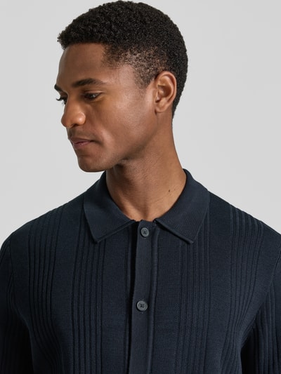 Männermodel trägt Regular Fit Freizeithemd aus reiner Baumwolle von Marc O'Polo × DFB Travel Collection, Strick, Optik: Unifarben, Nahaufnahme Oberkörper.