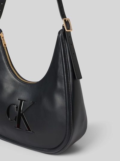 Produktfoto, czarna Henkeltasche mit Label-Detail od CK Calvin Klein, gładka powierzchnia, złote metalowe elementy, damska torebka