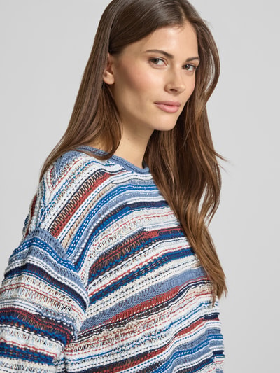 Frauenmodel trägt Strickpullover mit 1/2-Arm von Oui, gestreiftes Allover-Muster in Blau, Weiß, Braun und Rot, Nahaufnahme Oberkörper.