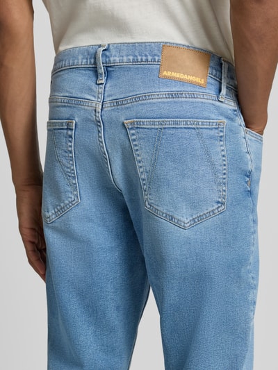 Männermodel trägt hellblaue Tapered Fit Jeans aus Baumwoll-Lyocell-Mix Modell 'AARJO TARPA' von ARMEDANGELS, Herren Tapered Fit Jeans, Nahaufnahme Rückansicht.