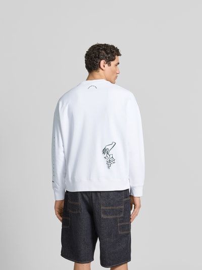 Männermodel trägt Oversized Sweatshirt aus Baumwoll-Mix von MAISON KITSUNÉ in Weiß mit floraler Label-Stitching, Rückenlänge 61 cm, Ganzkörperansicht Rückansicht.