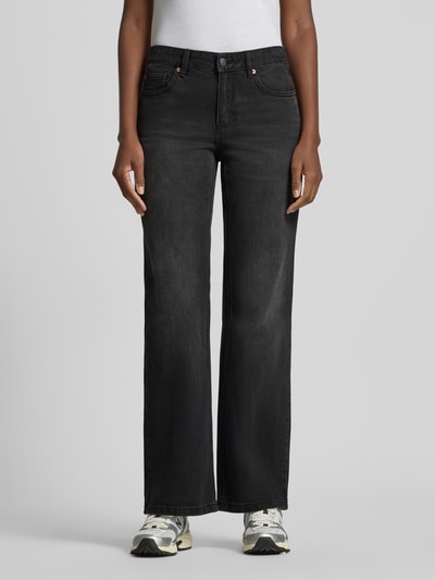Frauenmodel trägt Bootcut Jeans aus Baumwoll-Mix Modell 'ASTA' von Vero Moda in schwarzer Denim-Optik, 5-Pocket-Design, Ganzkörperansicht von vorne.