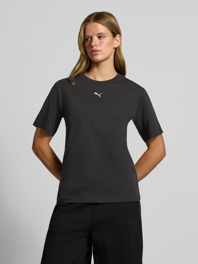 Frauenmodel trägt Relaxed Fit T-Shirt aus reiner Baumwolle von PUMA in Schwarz, dezentes Logo, schlichte glatte Textur, Ganzkörperansicht von vorne, Damen T-Shirt von PUMA.