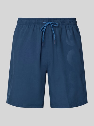 Produktfoto, Badeshorts mit Label-Schriftzug Modell 'ORCA' von BOSS in Uni-Dunkelblau, elastischer Bund mit Tunnelzug, seitliche Eingrifftaschen, glatte Textur.