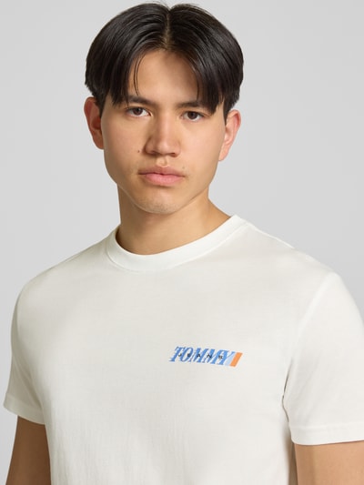 Männermodel trägt Regular Fit T-Shirt aus reiner Baumwolle von Tommy Jeans, Optik: Unifarben, Label-Print, Rundhals, Kurzarm, Jersey, Nahaufnahme Oberkörper.