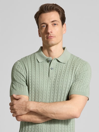 Männermodel trägt Slim Fit Poloshirt in Strick-Optik von Christian Berg Men in Hellgrün, reine Baumwolle, Polokragen, Nahaufnahme Oberkörper.