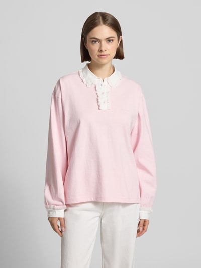 Frauenmodel trägt Oversized Poloshirt mit Kontrastbesatz Modell 'Jolina' von OH APRIL aus reiner Baumwolle, langärmlig, Label-Stitching, Ganzkörperansicht von vorne.