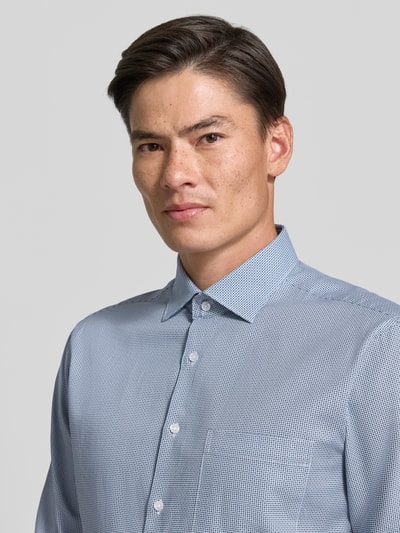 Männermodel trägt Regular Fit Businesshemd aus reiner Baumwolle Modell 'New Kent' von Seidensticker in Hellblau mit feinem Muster, Nahaufnahme Oberkörper, Herren Businesshemd von Seidensticker.