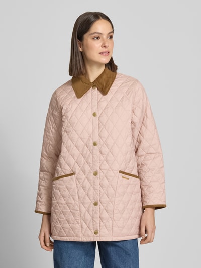 Vrouwenmodel draagt Regular Fit gewatteerd jack met platte kraag model 'LIDDESDALE' van Barbour, look: effen, waterafstotend, met applicatie met labelstitching, lange mouw, drukknoopsluiting. Ganzkörperansicht von vorne.