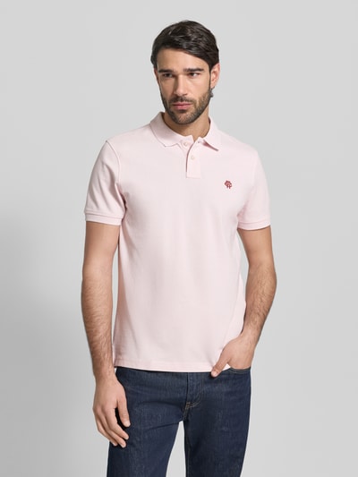 Männermodel trägt Slim Fit Poloshirt mit Logo-Stitching von MCNEAL in Rosa, kurze Ärmel, Polokragen, reine Baumwolle, Ganzkörperansicht von vorne.