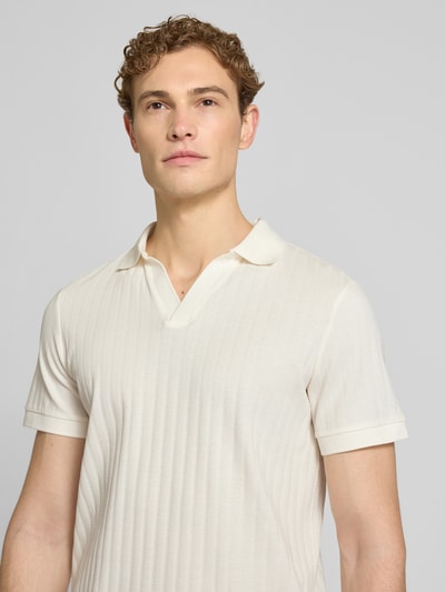 Männermodel trägt Regular Fit Poloshirt mit V-Ausschnitt Modell 'Baronito' von JOOP! Collection in Creme mit Strukturmuster, Nahaufnahme Oberkörper.