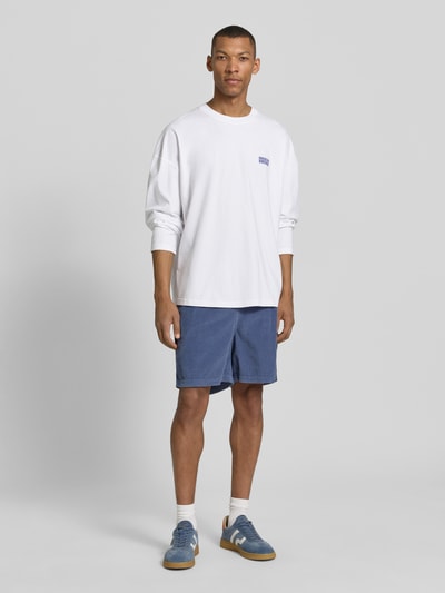 Männermodel trägt Longsleeve mit Logo-Print Modell 'GIXY' von American Vintage in Weiß, Loose-Fit aus Reine Baumwolle, Ganzkörperansicht von vorne.