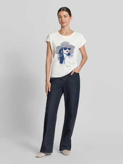 Frauenmodel trägt Damen T-Shirt aus Baumwoll-Viskose-Mix mit Motiv-Print von Christian Berg Woman, weiß mit blauem Print, Regular-Fit, Rundhalsausschnitt, Rückenlänge bei Größe S 59 cm, Ganzkörperansicht von vorne.