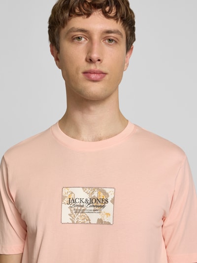 Männermodel trägt T-Shirt mit Label-Print von Jack & Jones in zartem Rosa, Reine Baumwolle, Gerader-Schnitt, Rundhalsausschnitt, Nahaufnahme Oberkörper.