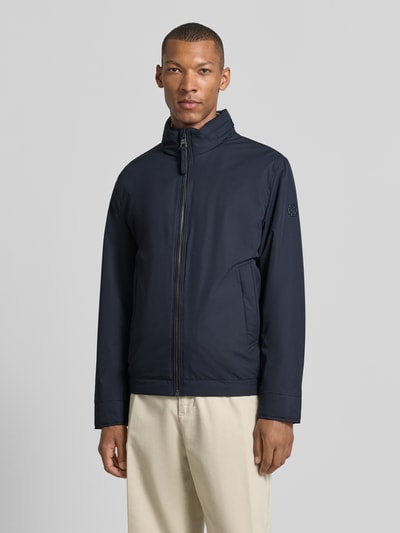 Mężczyzna nosi Regular Fit Steppjacke mit Stehkragen Modell 'LIGHT' von Strellson, ciemnoniebieska, gładka faktura, Ganzkörperansicht von vorne, kurtka pikowana męska marki Strellson.