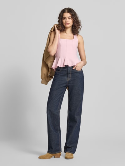 Frauenmodel trägt Slim Fit Top in Falten-Optik von Gina Tricot in Rosa, ärmellos, kombiniert mit Jeans, Ganzkörperansicht von vorne.