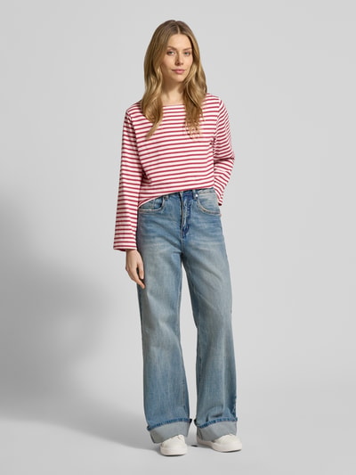 Vrouwenmodel draagt Loose Fit Langarmshirt aus reiner Baumwolle van Soyaconcept in wit-roze strepen, lange mouw, u-boothals, ganzlichaamsaanzicht van voren, ruglengte maat S 56 cm.