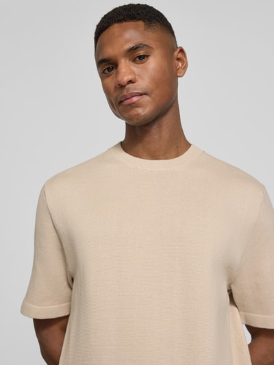 Männermodel trägt T-Shirt mit Label-Detail Modell 'MILANO' von Jack & Jones Premium, sandfarben, Baumwoll-Mix, Nahaufnahme Oberkörper.